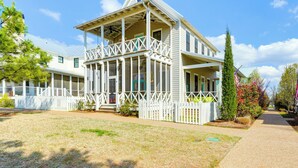 A two-story house with a porch and a white picket fence. - Carlton Landing Home w/ Poolside Lake View! (Eufaula)