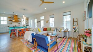 A spacious living room with a colorful striped rug, a blue sofa, and a wooden coffee table. - Carlton Landing Home w/ Poolside Lake View! (Eufaula)