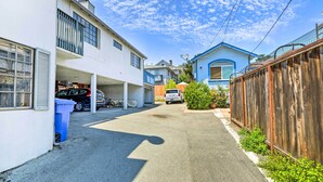 A residential street with houses, a garage, and a wooden fence. - Cozy Monterey Apartment - Walk to Wharf & Dtwn! (Monterey)
