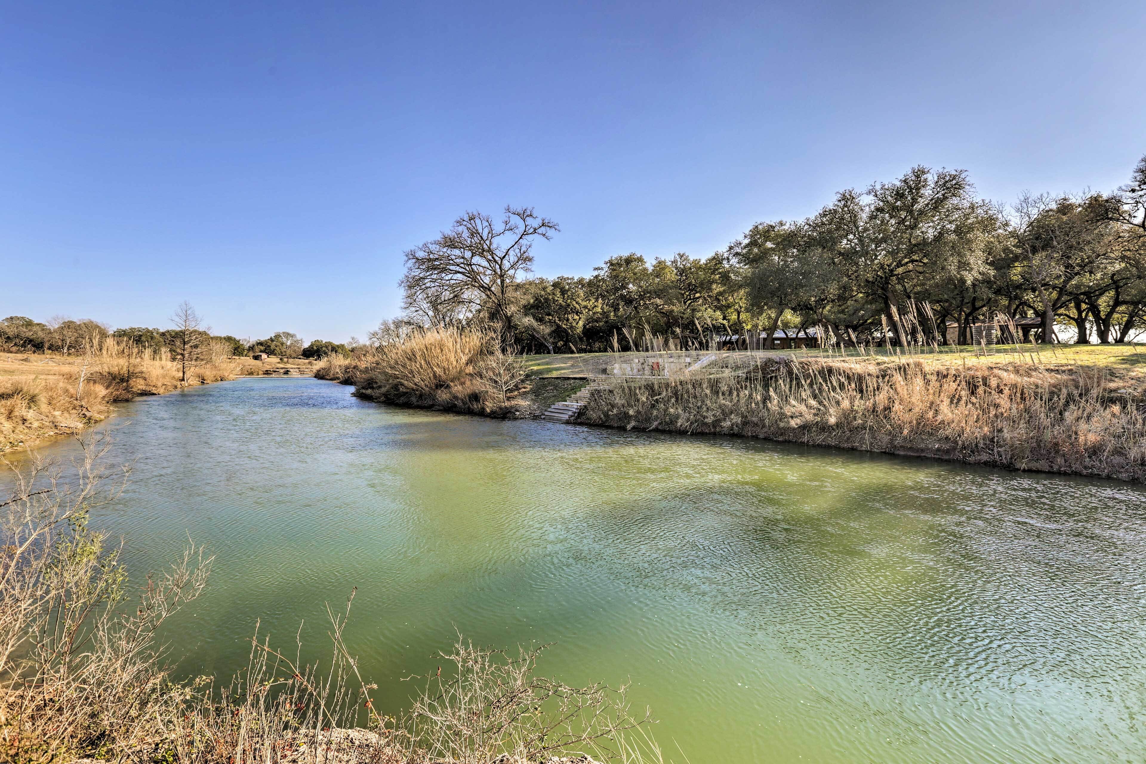 A river with a concrete embankment and a bridge.