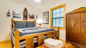 A bedroom with a wooden bed, a nightstand, a wardrobe, and a window with blinds. - Murphy Family Cabin w/ Fire Pit & Forest Views! (Murphy)
