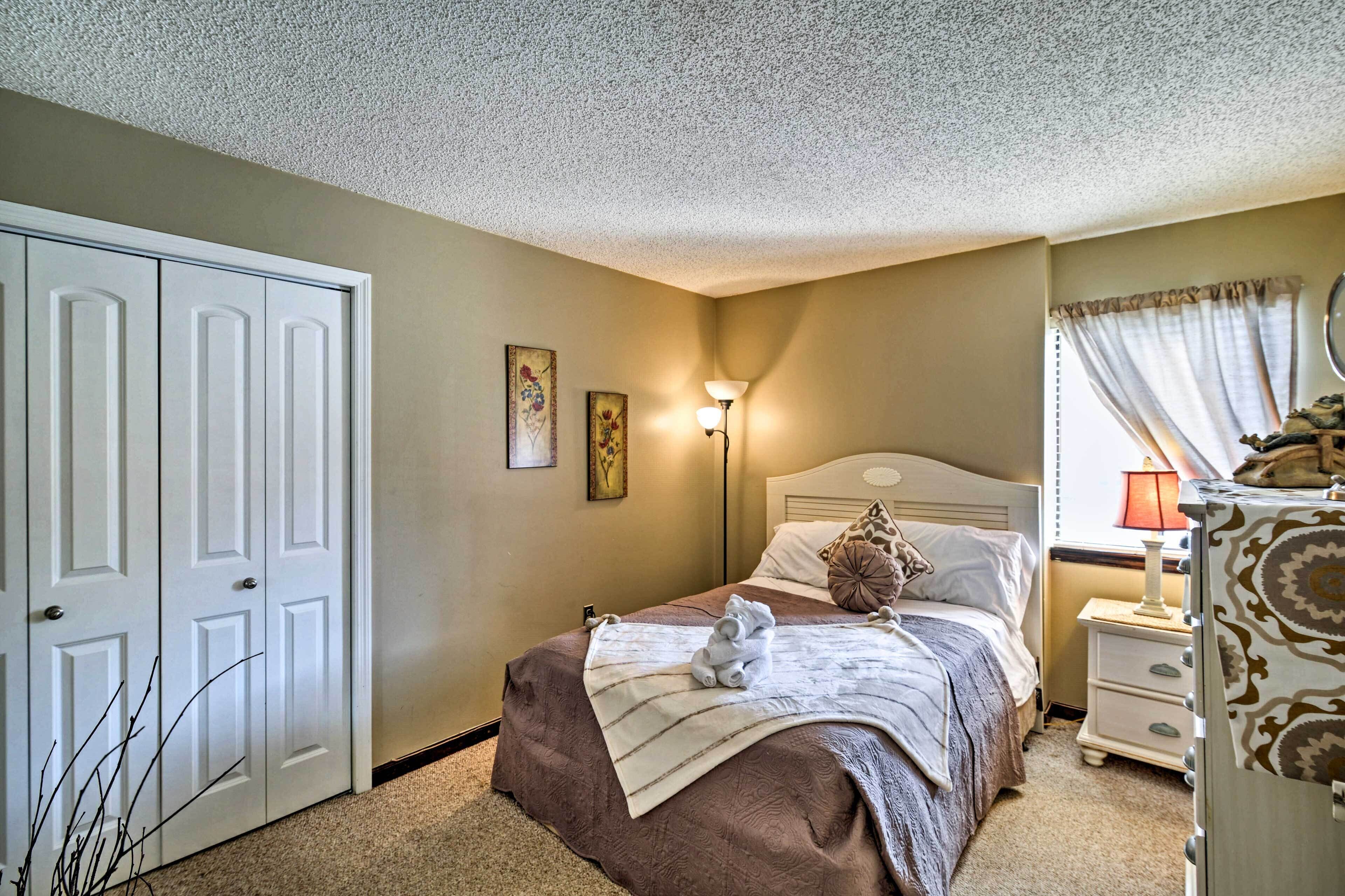 A bedroom with a bed, bedside table, lamp, and wardrobe.