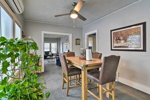 A dining area with a wooden table, four chairs, a ceiling fan, and a large framed picture on the wall. - Detroit Apartment - 5 Mi to Downtown! (Detroit)
