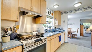 A kitchen with wooden cabinets, a stainless steel stove, and a blue countertop.