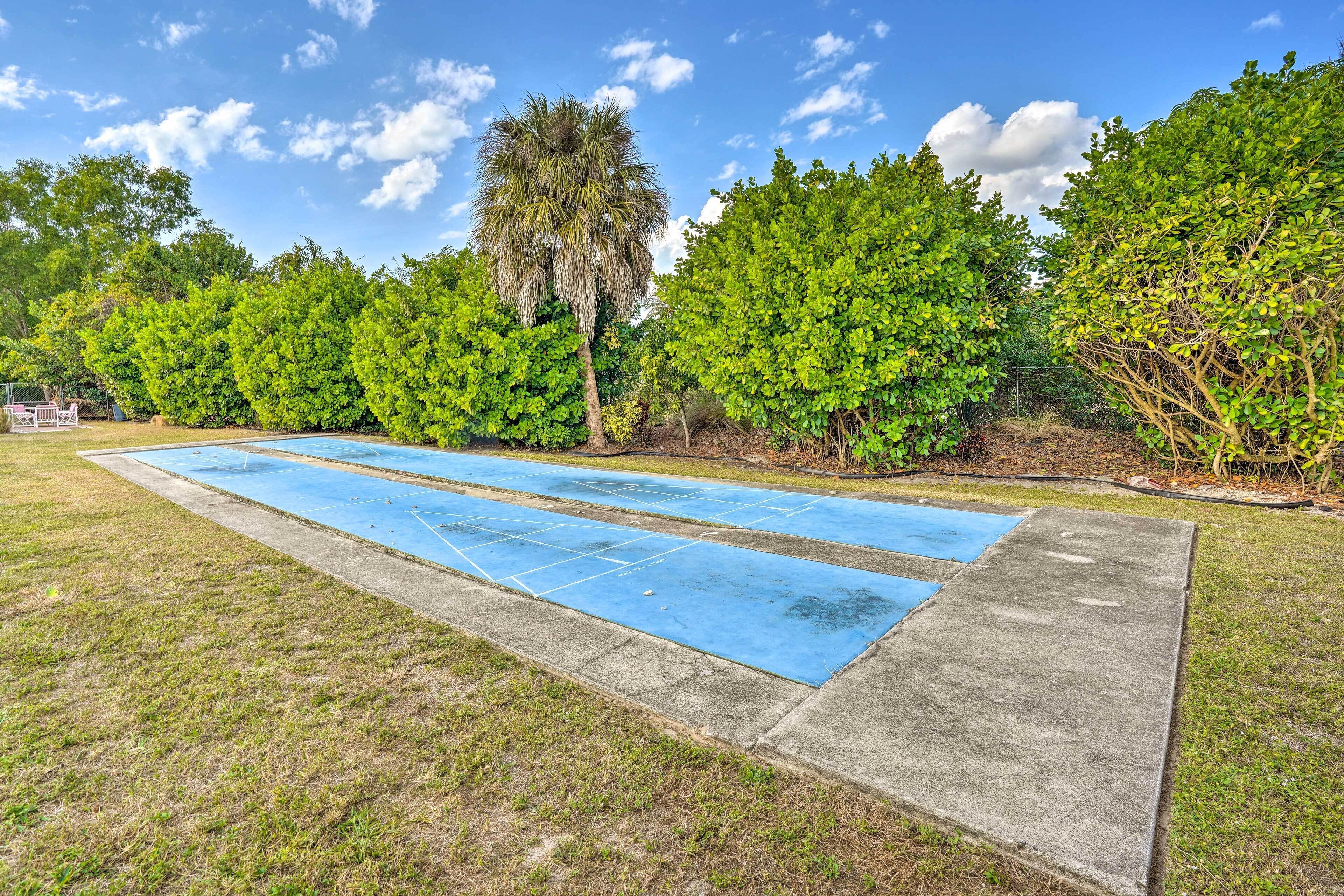 Una piscina con azulejos azules, rodeada de árboles verdes y un cielo despejado.