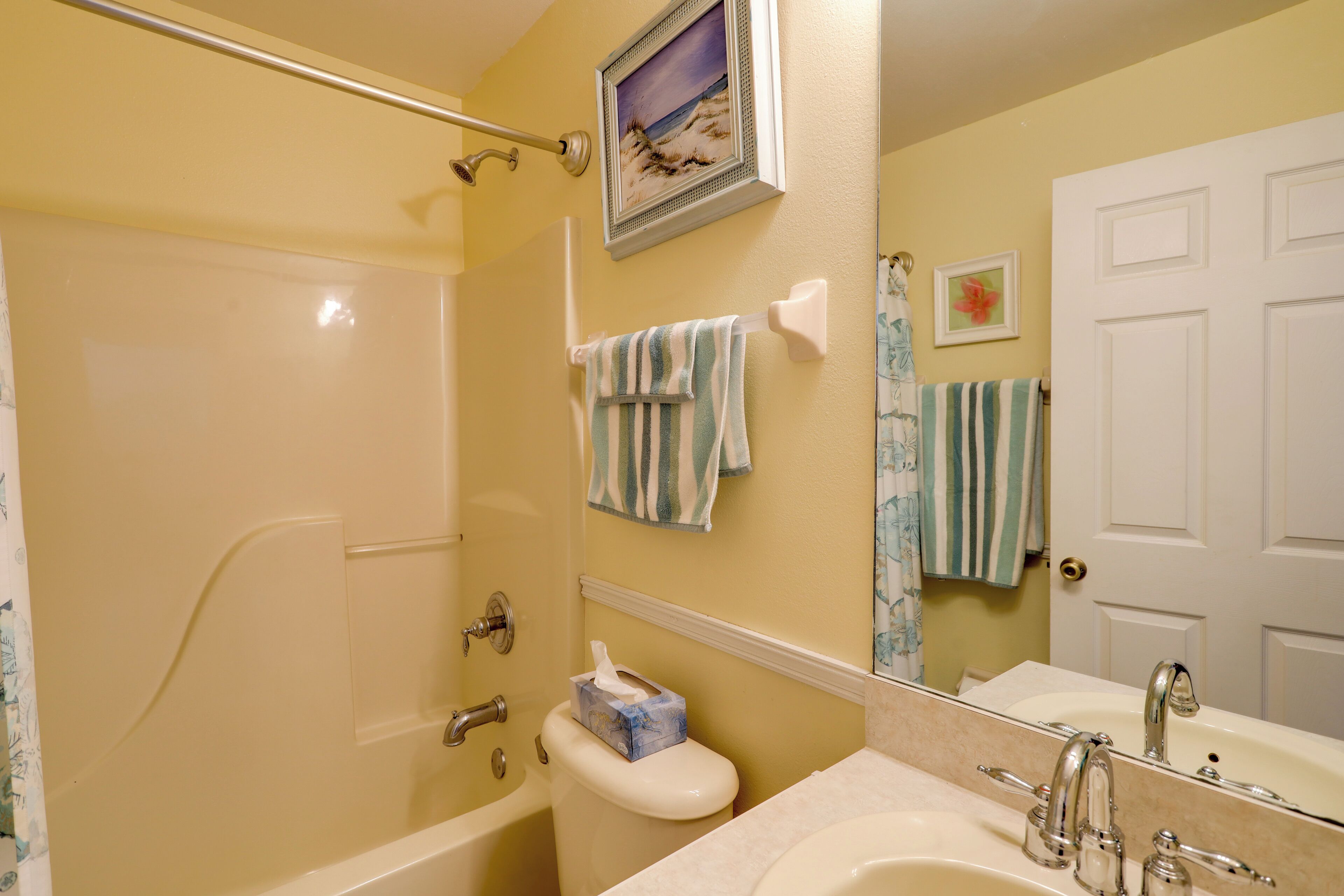 Ein Badezimmer mit Badewanne, Toilette, Waschbecken und Spiegel.