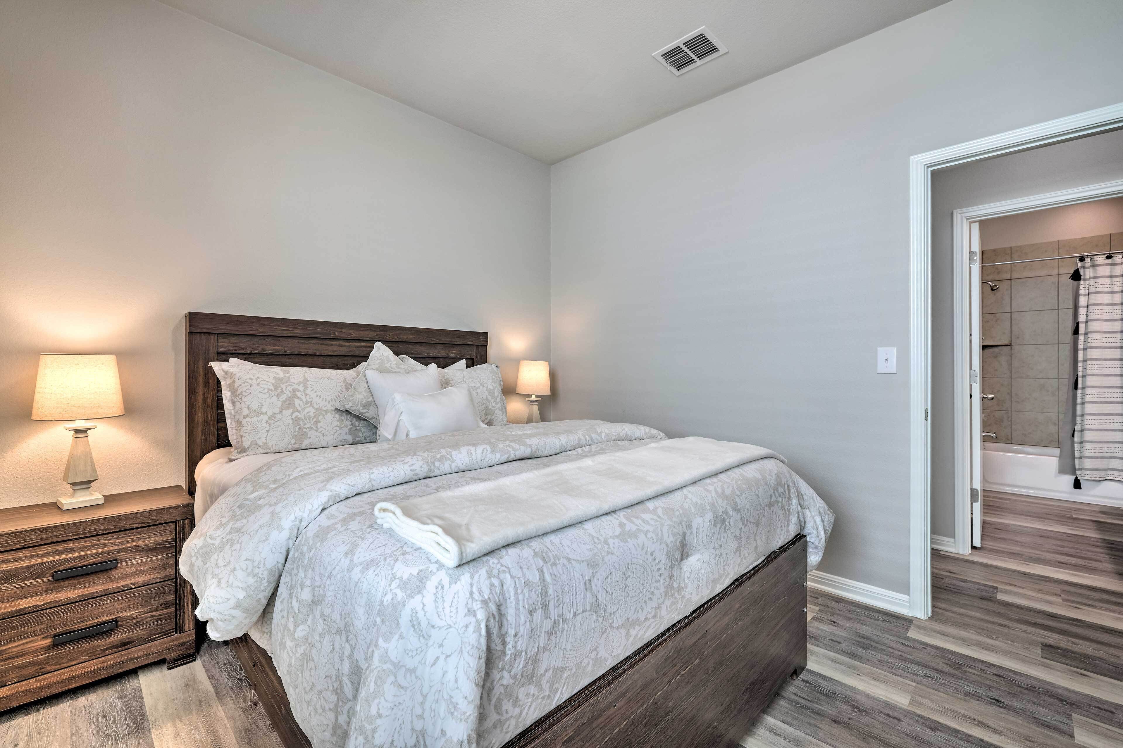 A bedroom with a bed, nightstands, and a bathroom door.