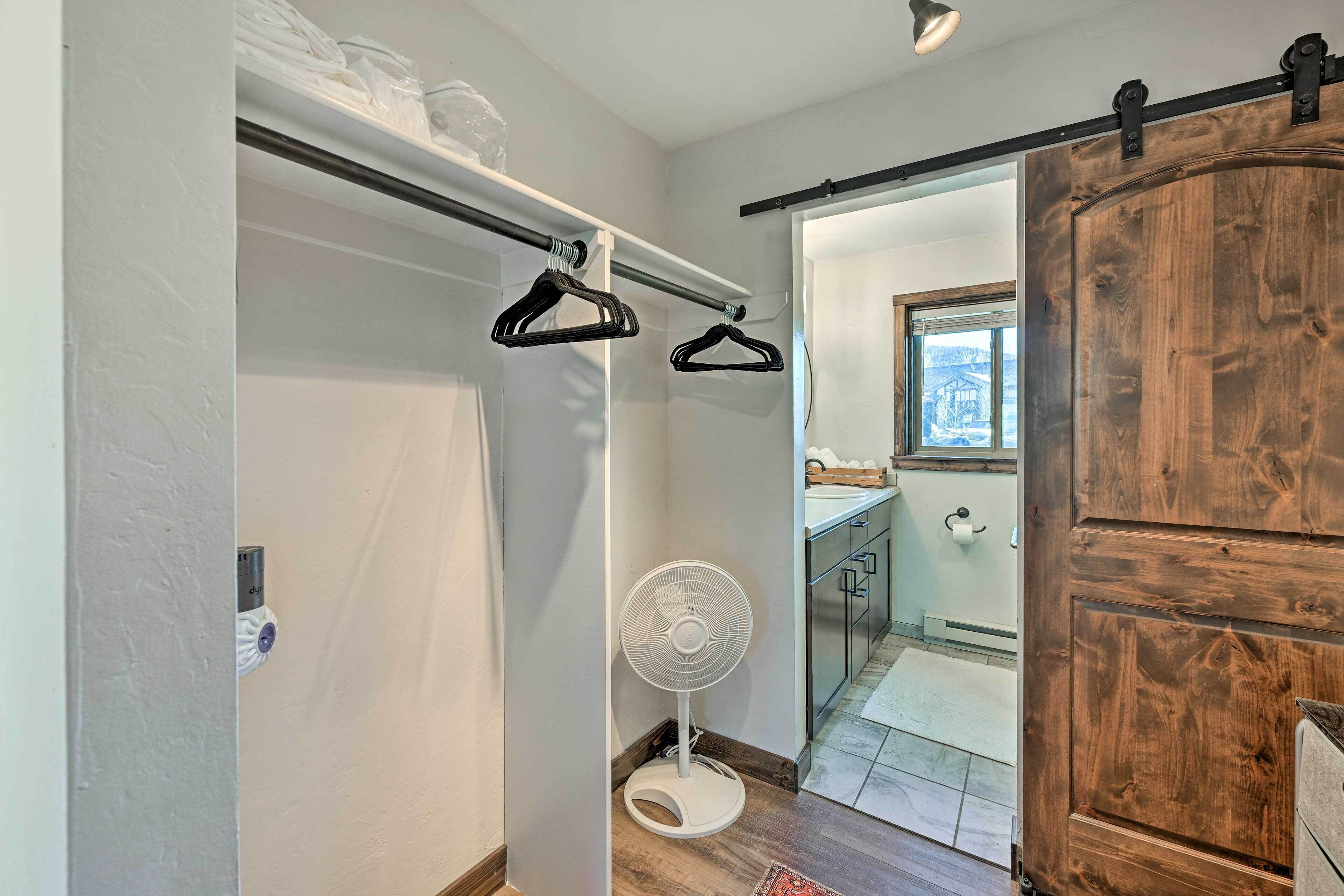 Une pièce avec une porte en bois, un ventilateur blanc et une porte coulissante de style grange.