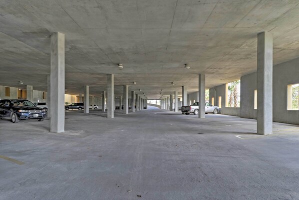 A large, open parking garage with concrete pillars and a flat floor. - Family Condo: Resort Pool Access & Ocean View (Dauphin Island)