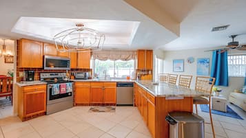 A modern kitchen with wooden cabinets, stainless steel appliances, and a central island.