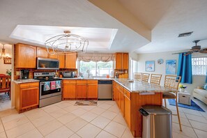 A modern kitchen with wooden cabinets, stainless steel appliances, and a central island. - Marco Island Retreat w/ Pool ~ 1 Mi to Beach (Marco Island)