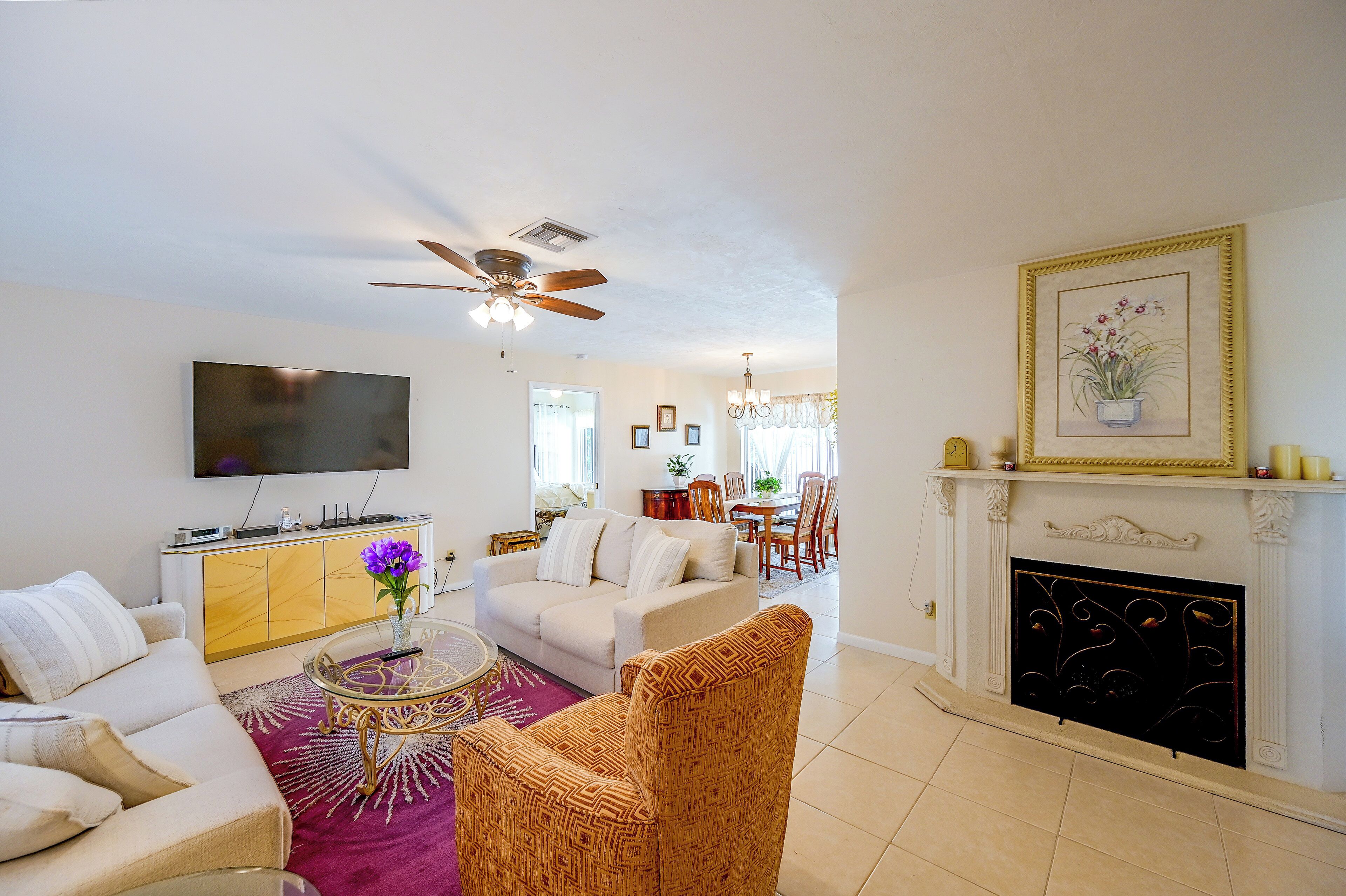 A living room with a sofa, a coffee table, a television, and a fireplace.
