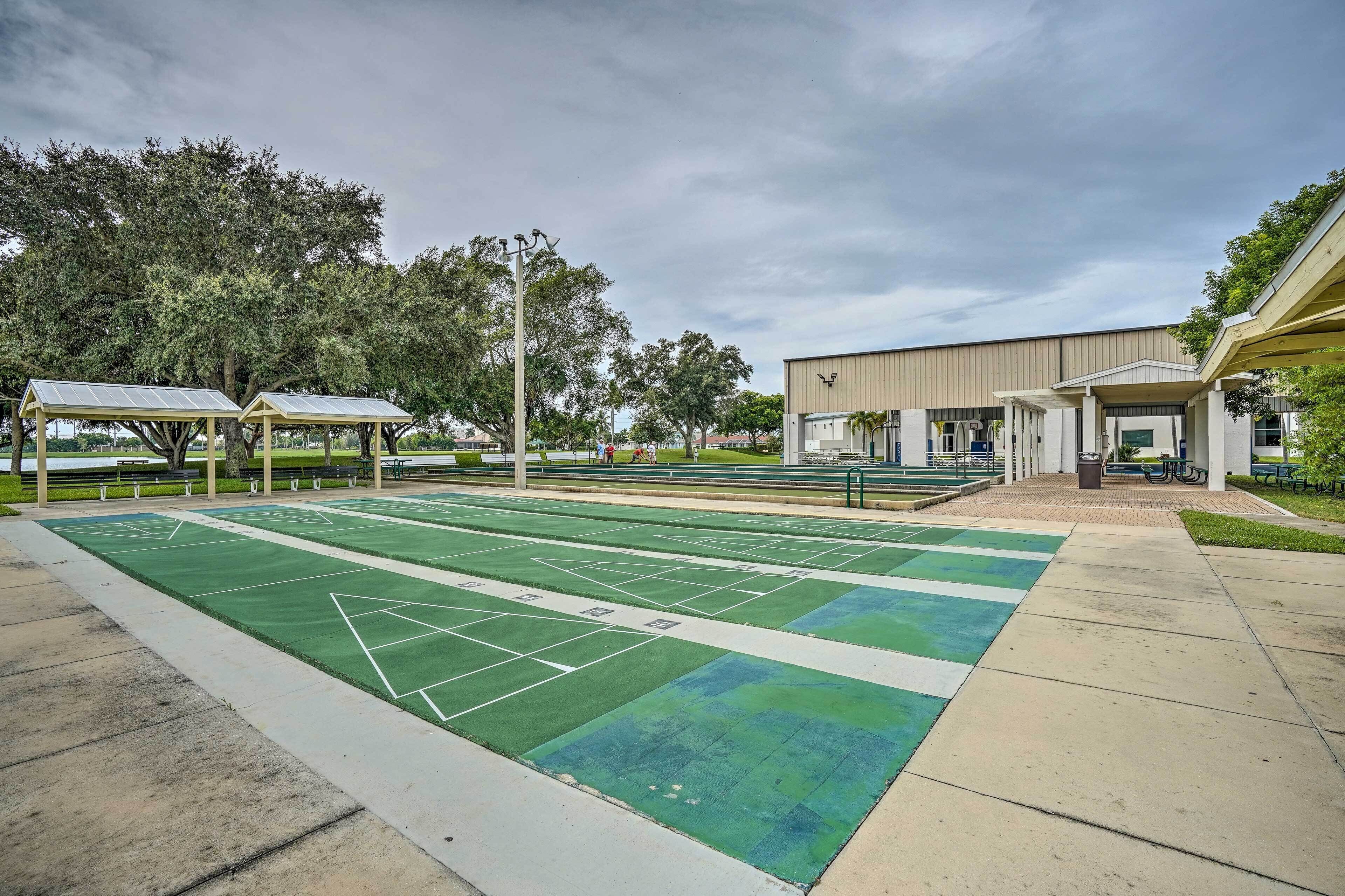 Un campo da tennis con pannelli solari, una zona relax coperta e un edificio con ingresso protetto.