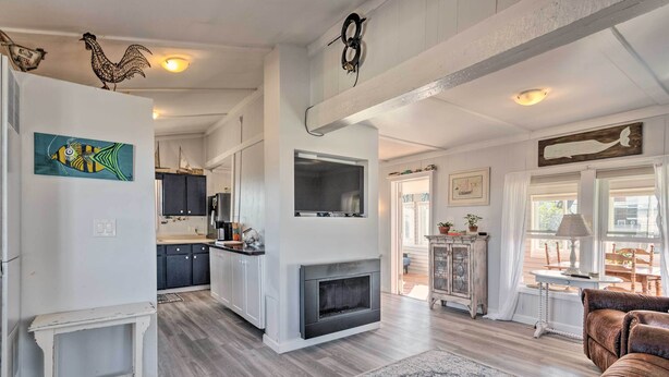A spacious living room with a fireplace, a dining area with a table and chairs, and a kitchen with modern appliances.