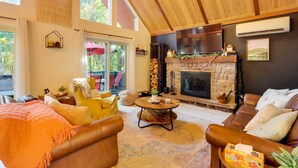 A cozy living room with leather sofas, a fireplace, and a stone wall. - 3 Mi to Slopes! Poconos Chalet w/ Hot Tub & Sauna (Lake Harmony)