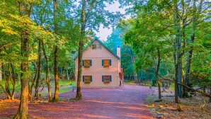 A two-story wooden cabin surrounded by trees with a gravel driveway leading to the entrance. - 3 Mi to Slopes! Poconos Chalet w/ Hot Tub & Sauna (Lake Harmony)