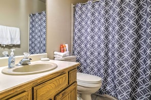 A bathroom with a sink, mirror, and toilet.