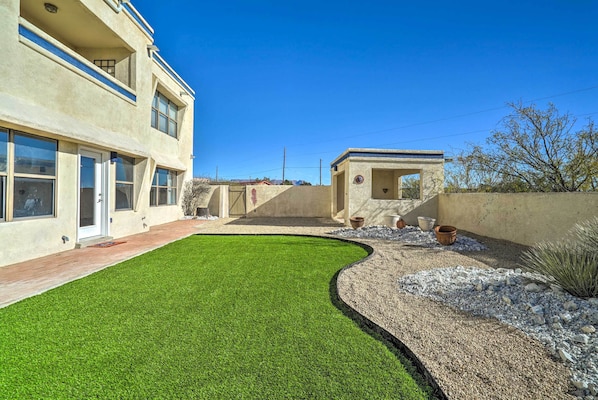 A modern two-story building with a well-maintained lawn and a small patio area.