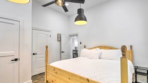 A bedroom with a wooden bed, white walls, a ceiling fan, and a pendant light. - Charming Home ~ 7 Mi to Thanksgiving Point (American Fork)
