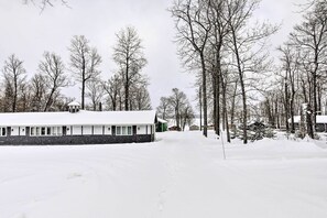 Un paisaje nevado con una hilera de cabañas y un edificio grande con tejado cubierto de nieve.