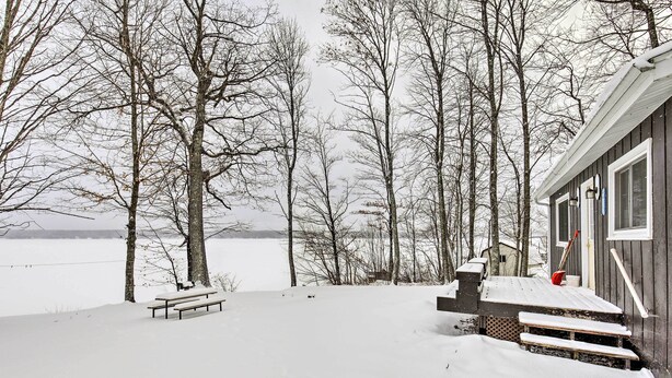 A wooden cabin with a snow-covered deck and a bench. - Tranquil Marenisco Cabin on Lake Gogebic! (Marenisco)