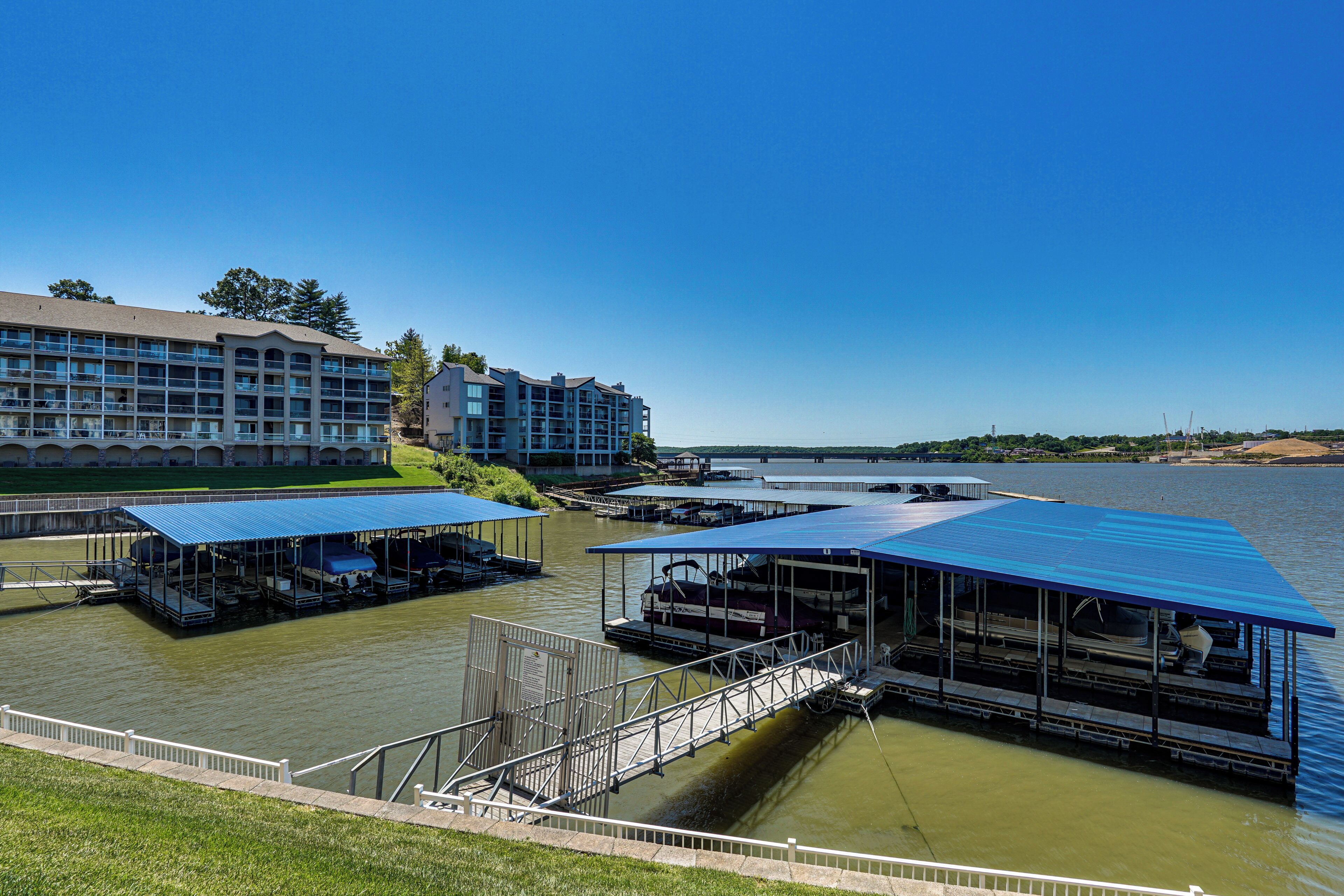 Un hôtel situé au bord de l’eau, avec plusieurs bateaux amarrés, une zone abritée pour lancer les bateaux à l’eau et un grand bâtiment doté de balcons.
