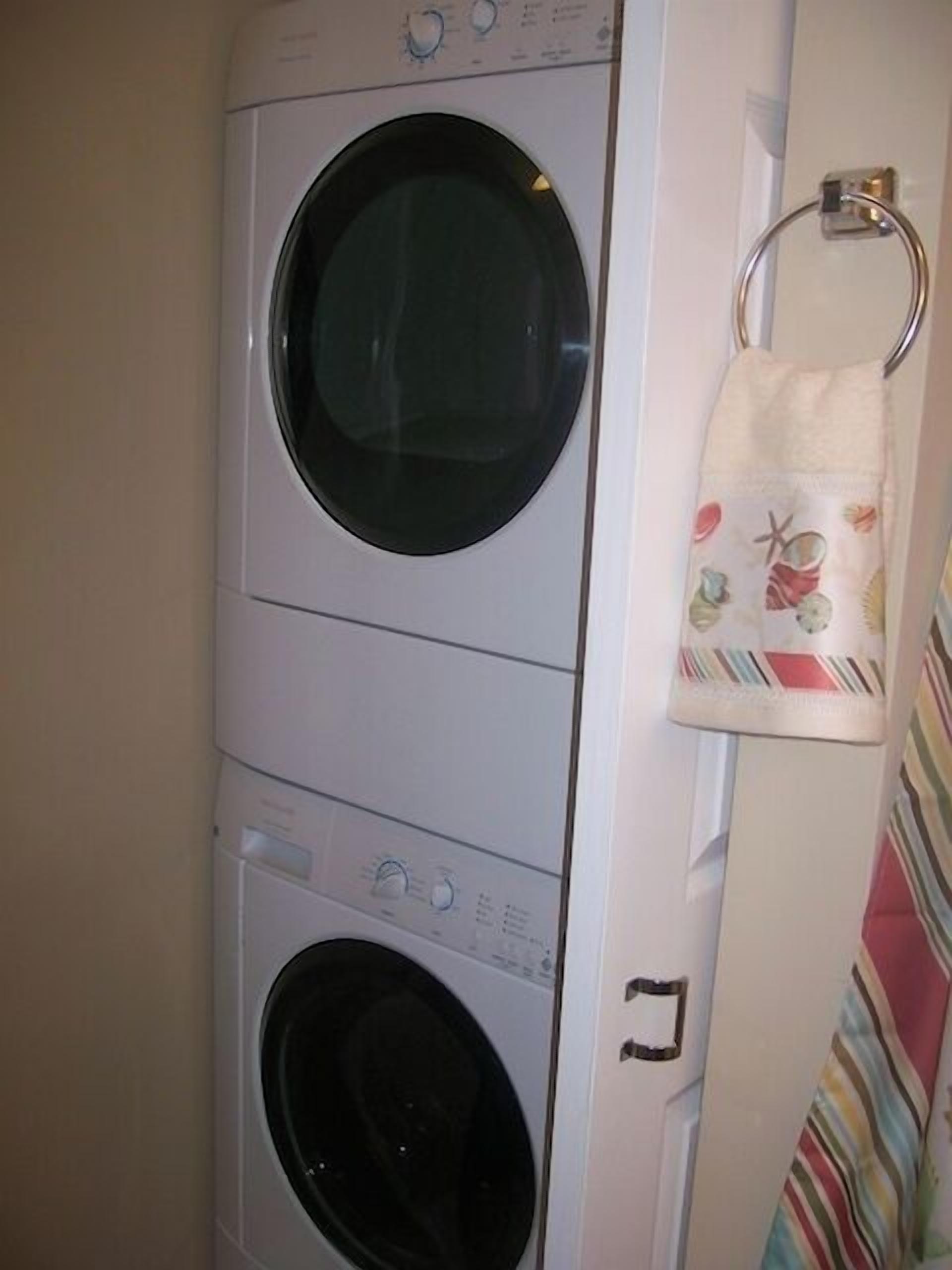 A front-loading washing machine with a control panel and a dryer below it.
