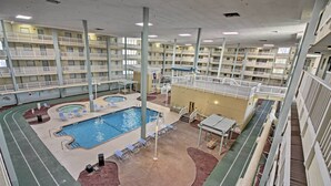 A multi-level indoor swimming pool with multiple decks and lounge areas.