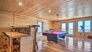 A wooden interior with a pool table, a bar area, and large windows. - Hot Tub & Game Room: Mountaintop Cabin in Murphy! (Murphy)