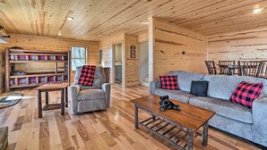 A cozy log cabin interior with a sofa, armchairs, a coffee table, and a chessboard. - Hot Tub & Game Room: Mountaintop Cabin in Murphy! (Murphy)