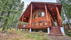 Eine Holzhütte mit Balkon, umgeben von Bäumen.