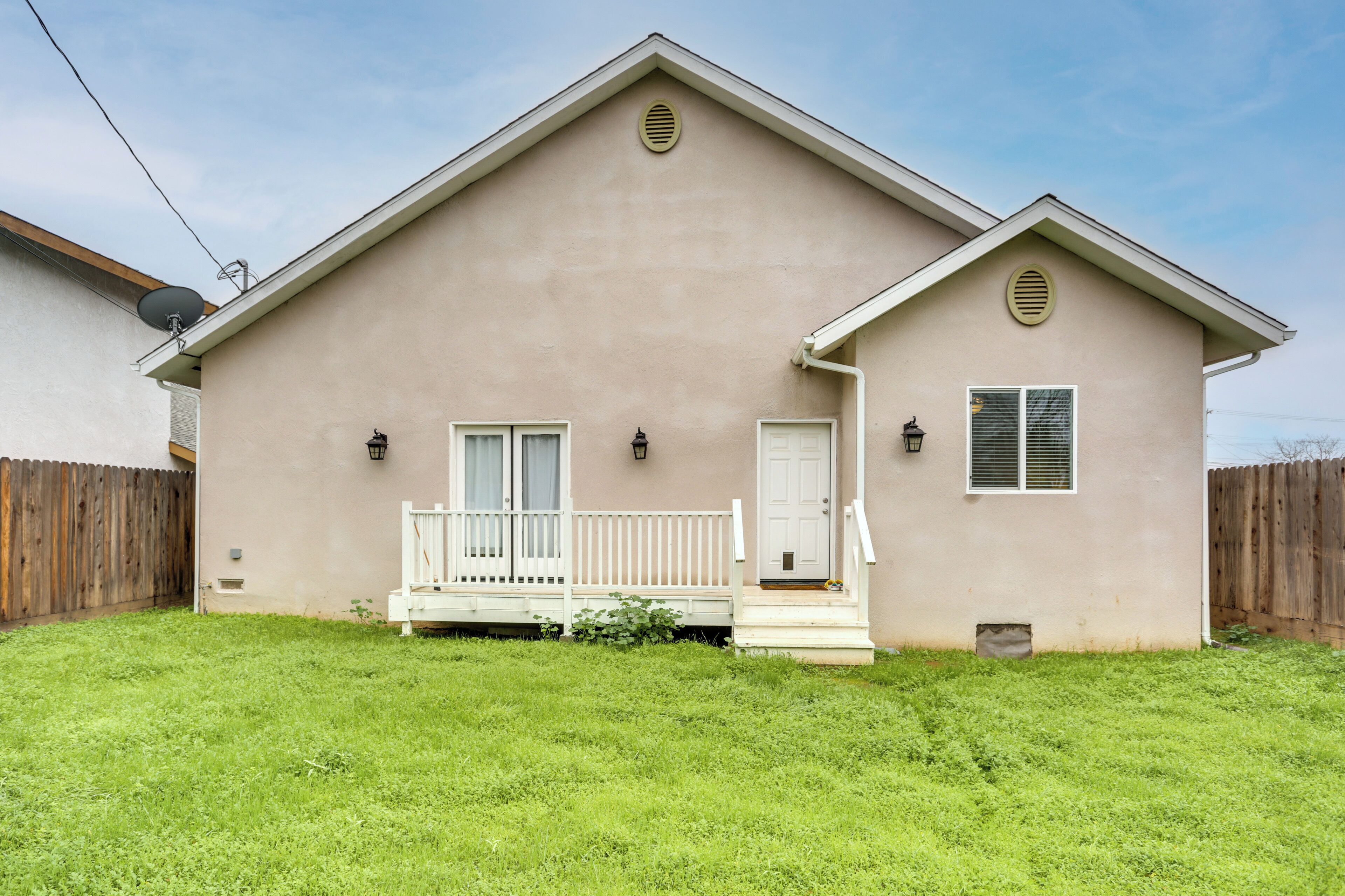 A single-story house with a front porch, a door, and a window with shutters.
