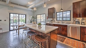 A modern kitchen with a large island, stainless steel appliances, and a bar area with stools. - Custom Home < 2 Mi to Downtown Boise (Boise)