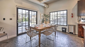 A dining area with a wooden table and metal chairs, large windows, and a view of the outside. - Custom Home < 2 Mi to Downtown Boise (Boise)