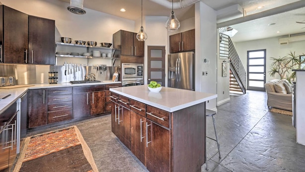 A modern kitchen with dark wood cabinets, stainless steel appliances, and a central island. - Custom Home < 2 Mi to Downtown Boise (Boise)