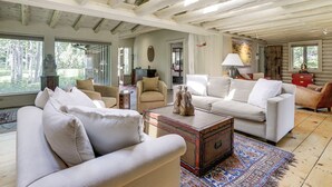 A spacious living room with a high ceiling, large windows, and a cozy fireplace. - Snowmass Home w/ Hot Tub, Fireplace, & Mtn Views! (Snowmass)