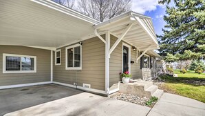 A single-story house with a covered porch, a front door, and a small front yard with steps leading up to the door.
