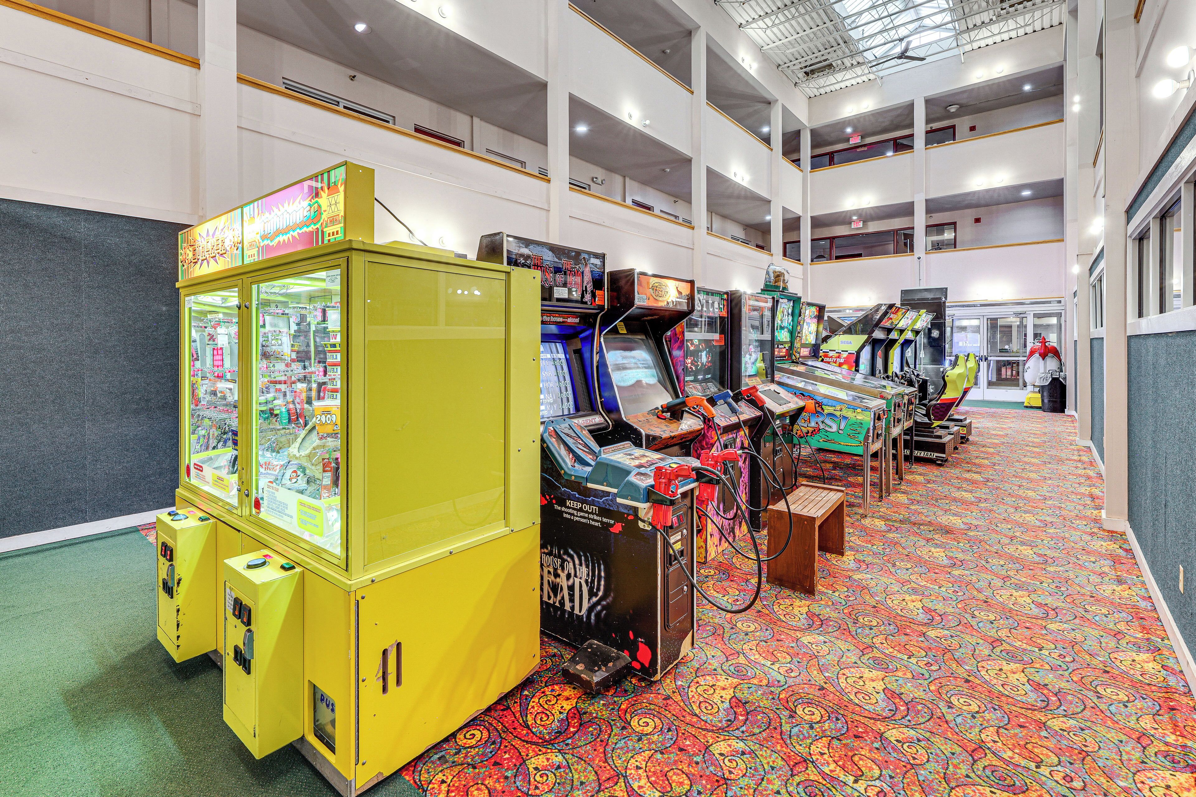 A brightly lit arcade area with multiple gaming machines, a yellow vending machine, and a patterned carpet.