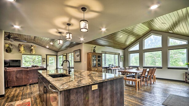 Una cocina amplia con una isla grande, pisos de madera y un comedor con mesa y sillas.