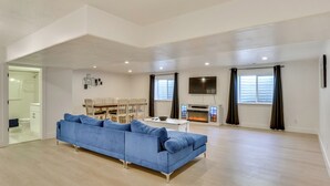 A spacious living room with a blue sofa, a flat-screen TV, and a fireplace. - Sleek & Modern Morgan Abode: Great for Families! (Morgan)