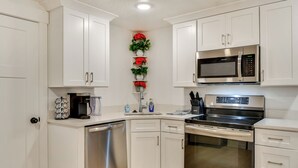A modern kitchen with white cabinetry, a stainless steel dishwasher, a built-in oven, and a microwave. - Sleek & Modern Morgan Abode: Great for Families! (Morgan)