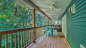A wooden deck with a railing, a ceiling fan, and a view of trees. - Peaceful Sevierville Home w/ Private Hot Tub! (Sevierville)