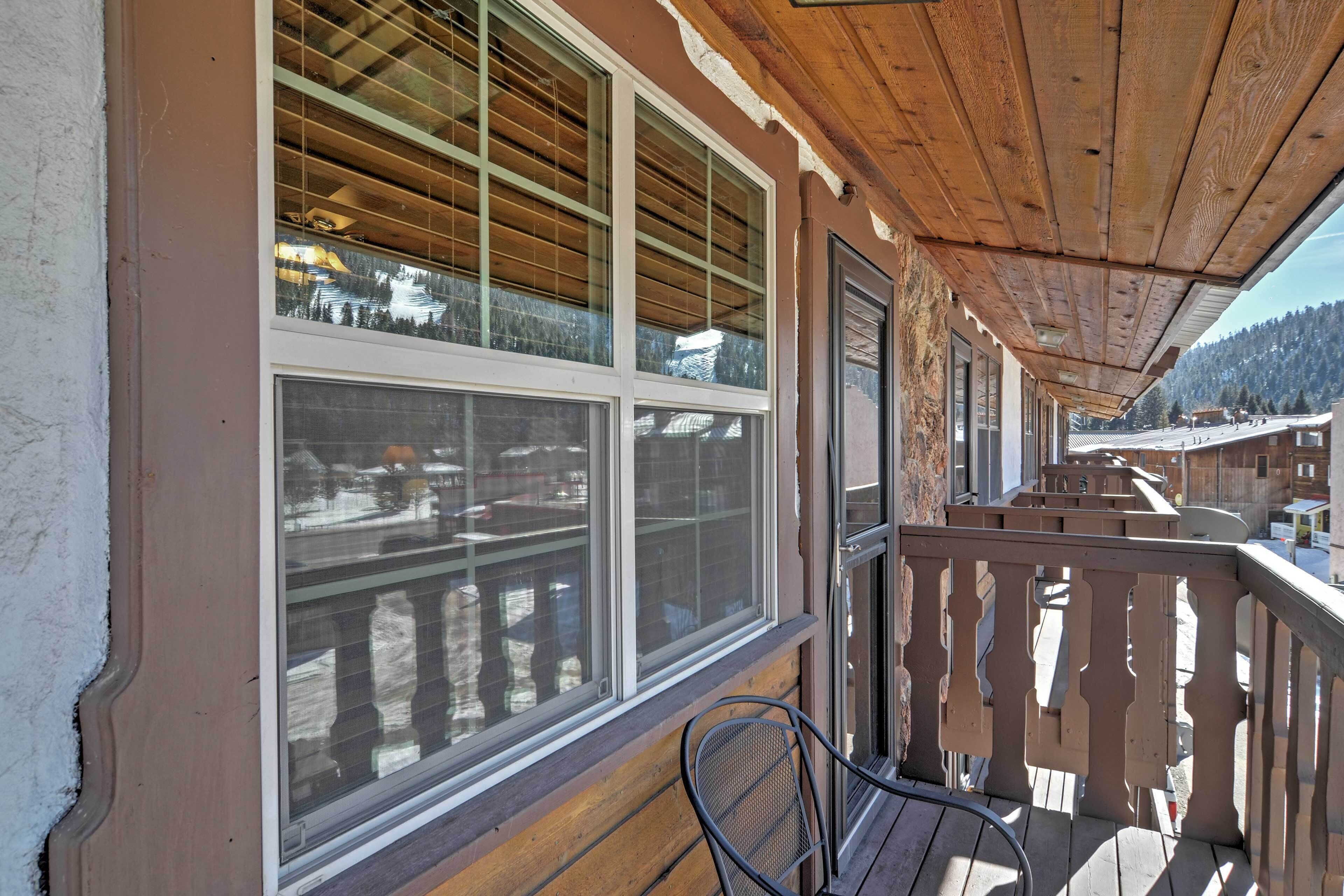 A wooden balcony with a view of a snowy mountain.