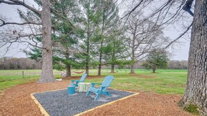 A seating area with two blue Adirondack chairs, a small table, and a fire pit. - Deck & Pasture Views! Bealeton Farmhouse Escape (Bealeton)