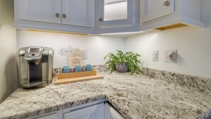 A kitchen with white cabinets, a coffee maker, a tray with coffee cups, and a potted plant. - Deck & Pasture Views! Bealeton Farmhouse Escape (Bealeton)