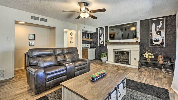 A living room with a leather sofa, wooden coffee table, and a fireplace. - Charming Santa Teresa Retreat w/ Backyard! (Santa Teresa)