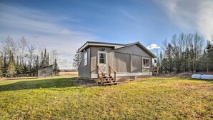 A rustic cabin with a wooden exterior, a small porch, and a single door. - Cornell Home w/ Fire Pit & Hunting Access! (Cornell)