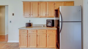 A kitchen with wooden cabinets, a stainless steel refrigerator, and a toaster oven. - Tranquil Delmar Home ~ 7 Mi to Salisbury! (Delmar)