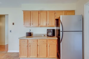 A kitchen with wooden cabinets, a stainless steel refrigerator, and a toaster oven. - Tranquil Delmar Home ~ 7 Mi to Salisbury! (Delmar)