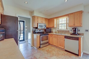 A modern kitchen with wooden cabinets, stainless steel appliances, and a dishwasher.